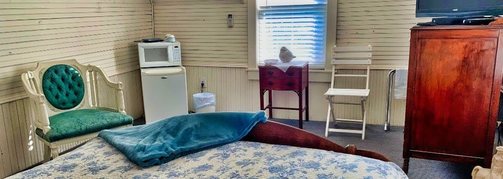 Cozy rustic bedroom interior with vintage furniture and modern amenities at Mountain Harbour lodge.